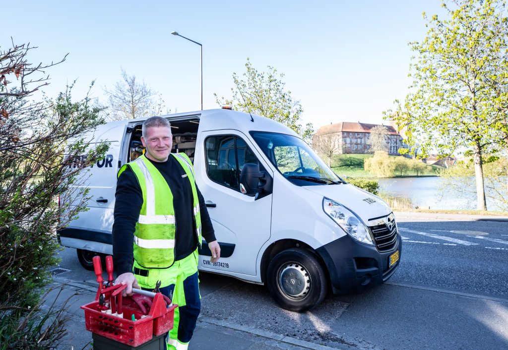 Plumber with Tool Box Standing Beside Service Van on a Sunny Day