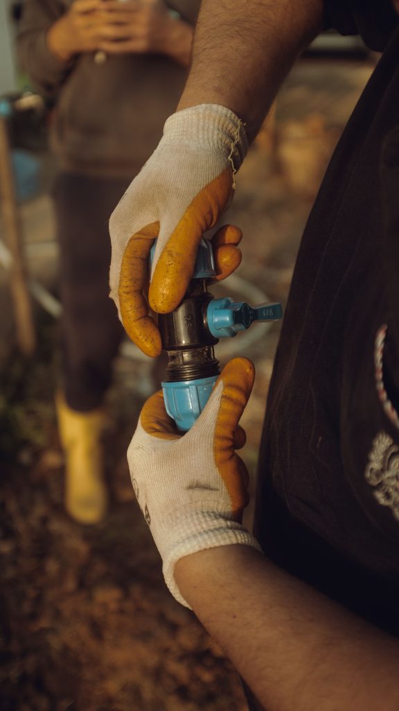 Plumber Wearing Gloves Connecting Water Pipe Fittings Outdoors