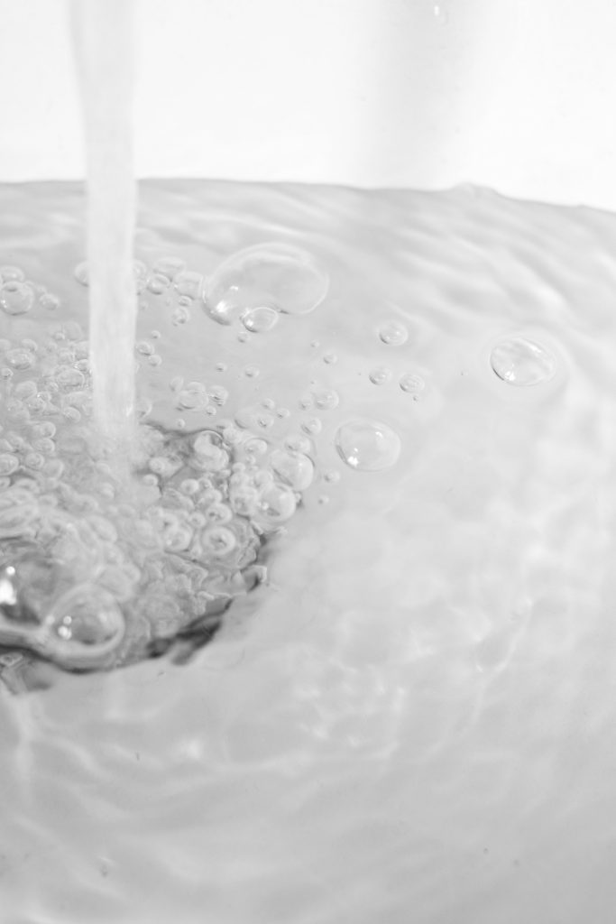 Water Flowing Down Drain with Bubbling Water Surface