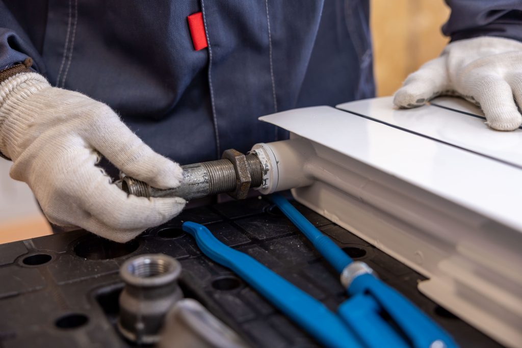 Plumber Repairing Pipe with Tools on a Workbench