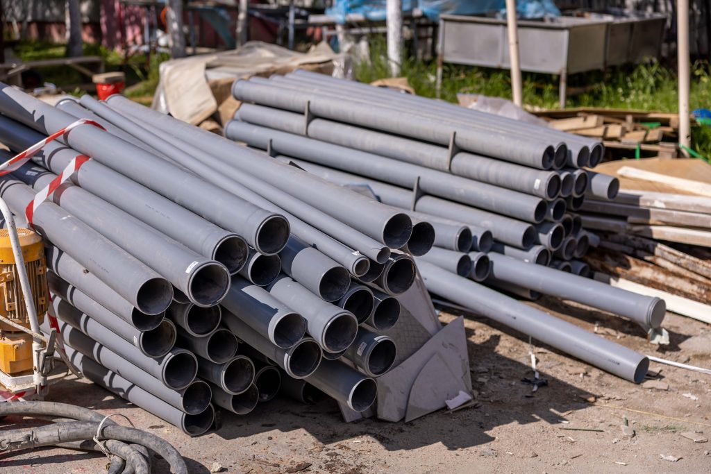 Stacked Gray PVC Pipes on Construction Site for Sewer Line Repair