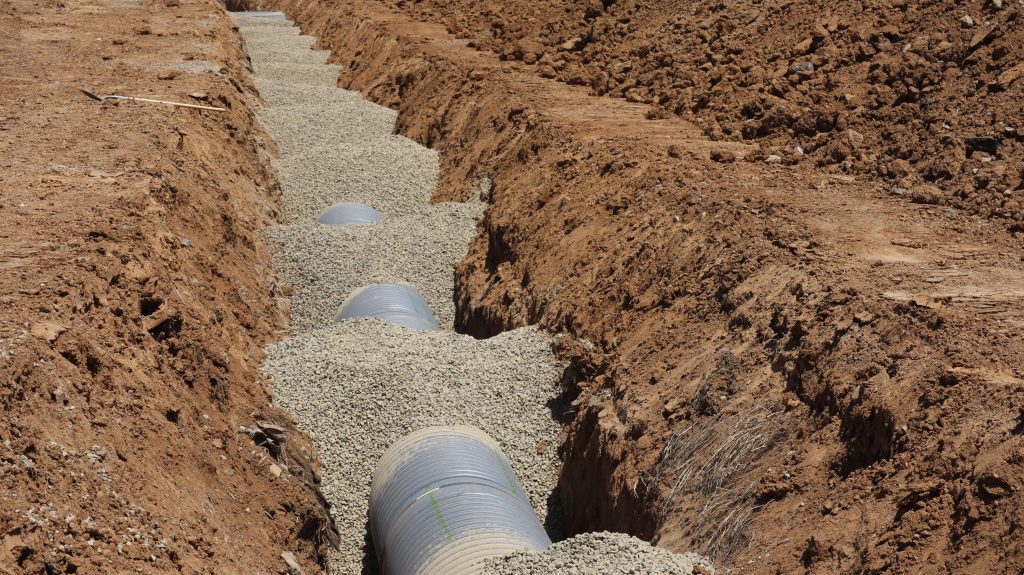 Trench with Newly Installed Sewer Line and Gravel Backfill