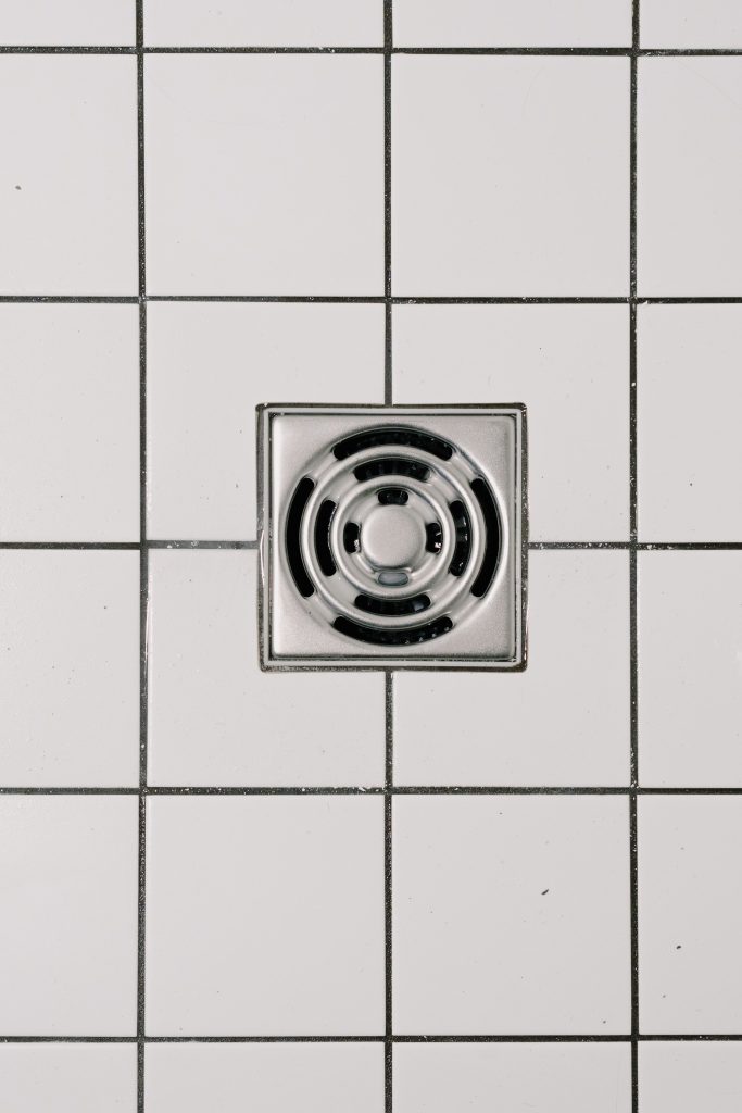 Square Floor Drain on White Tiled Bathroom Floor