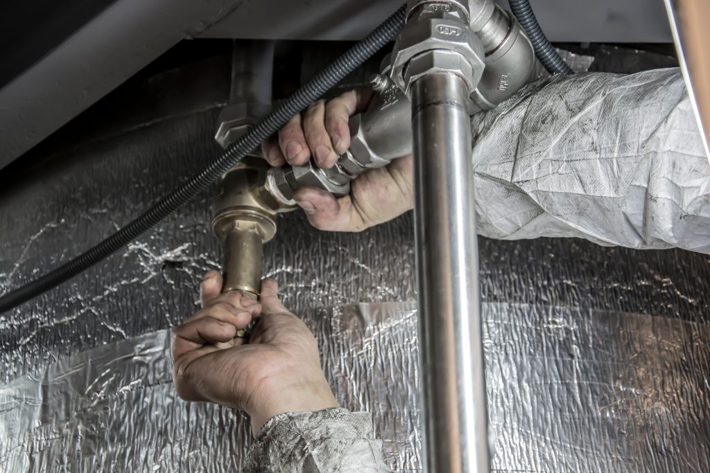 Plumber Repairing Pipes Under Sink for Emergency Plumbing Services Near Me